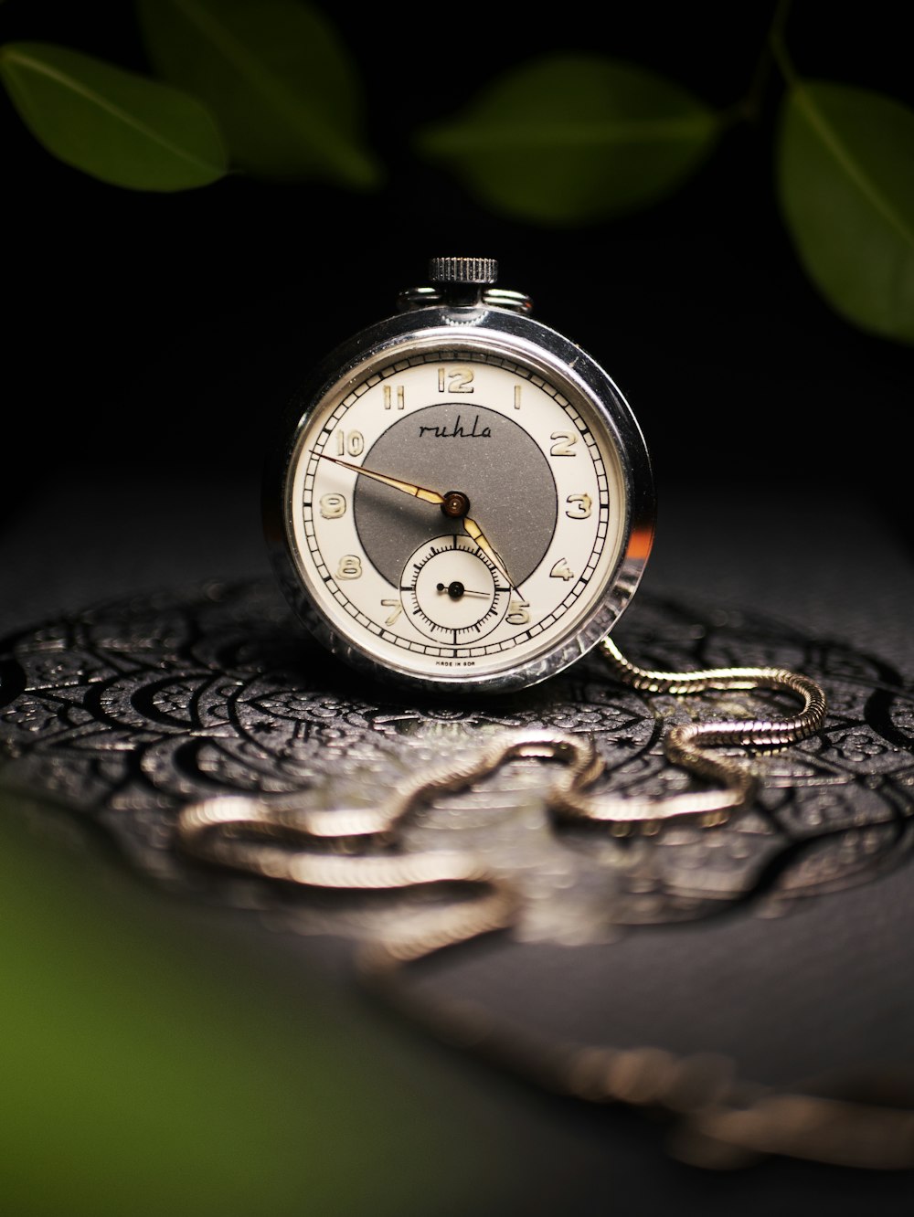 round grey pocket watch on grey surface