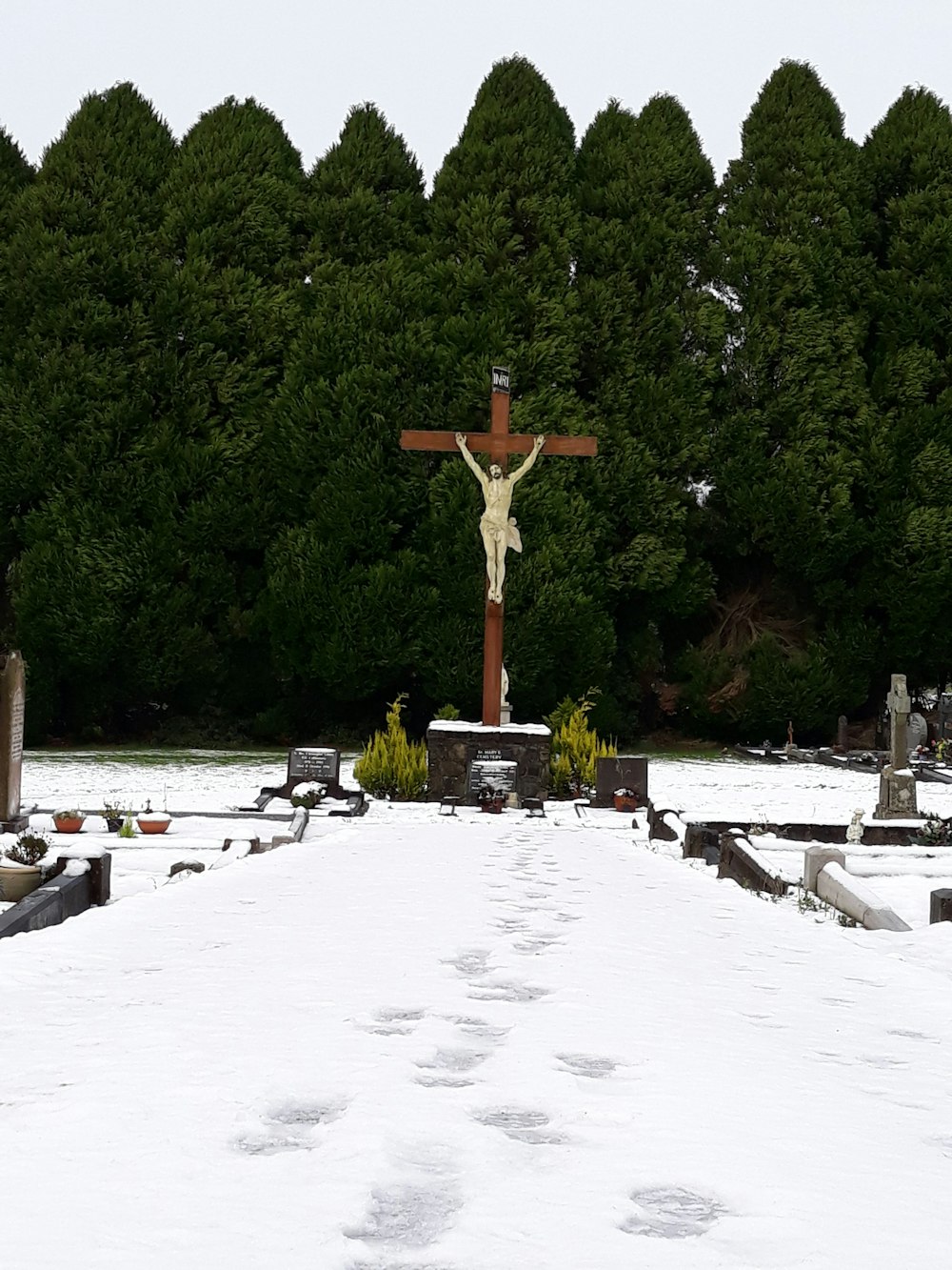 brown and white crucifix statue in cemetery