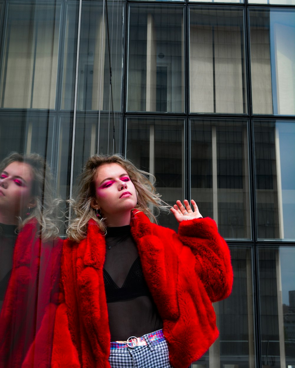 woman leaning on clear glass wall