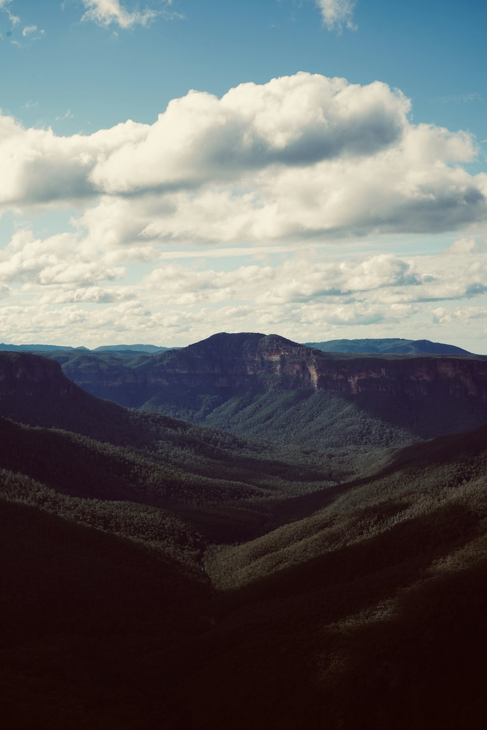 a scenic view of a mountain range with clouds in the sky