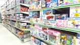 Wide-angle photo of a well-lit warehouse with organized shelves filled with toys and games.