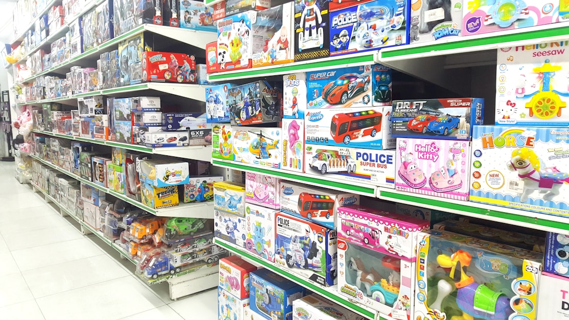 A colorful assortment of children's toys neatly arranged on shelves in a bright, inviting store setting.