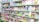 A store shelf filled with various colorful stationery items and art supplies, including pens, pencils, notebooks, and paint sets. The shelves are well-organized, displaying products in various vibrant packages. Some toy items and educational kits are also visible.