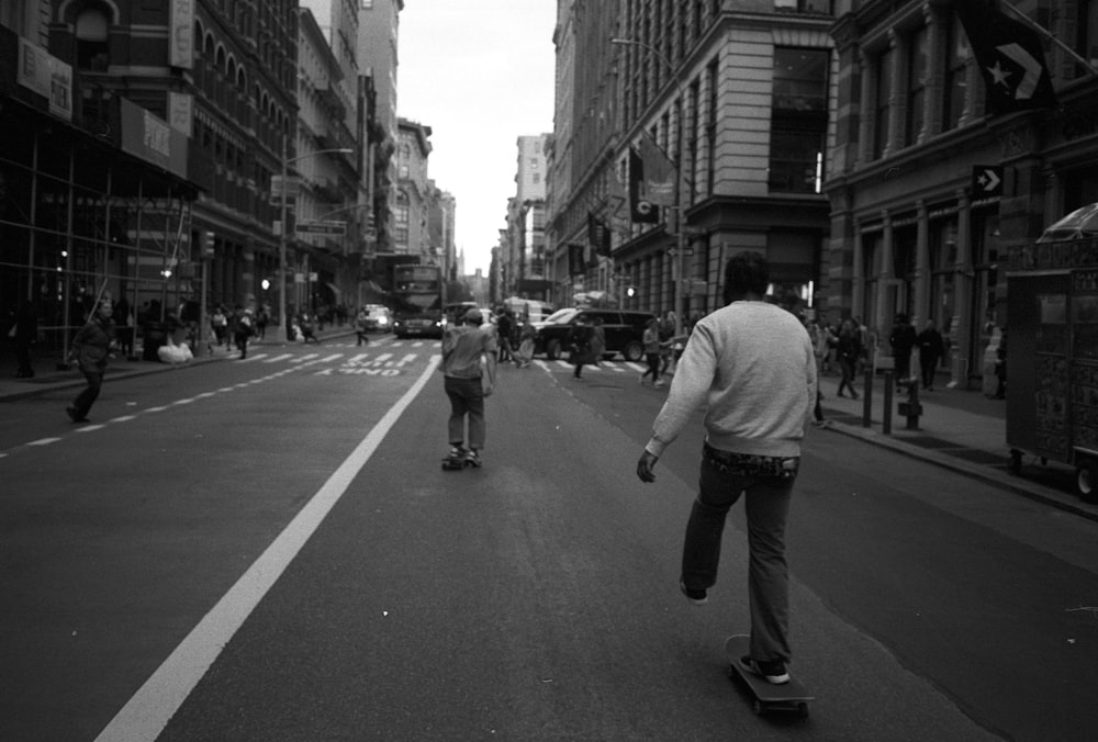 grayscale photo of skaters on the road