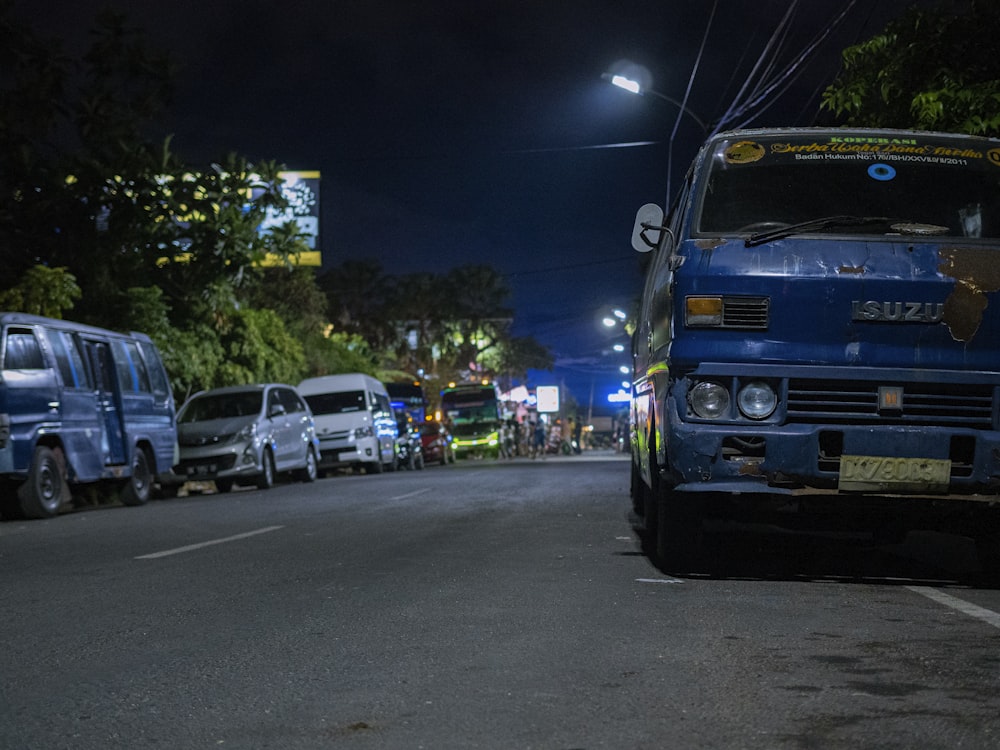 blue Isuzu truck on asphalt road