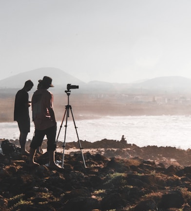 two person standing in front of camera across mountain