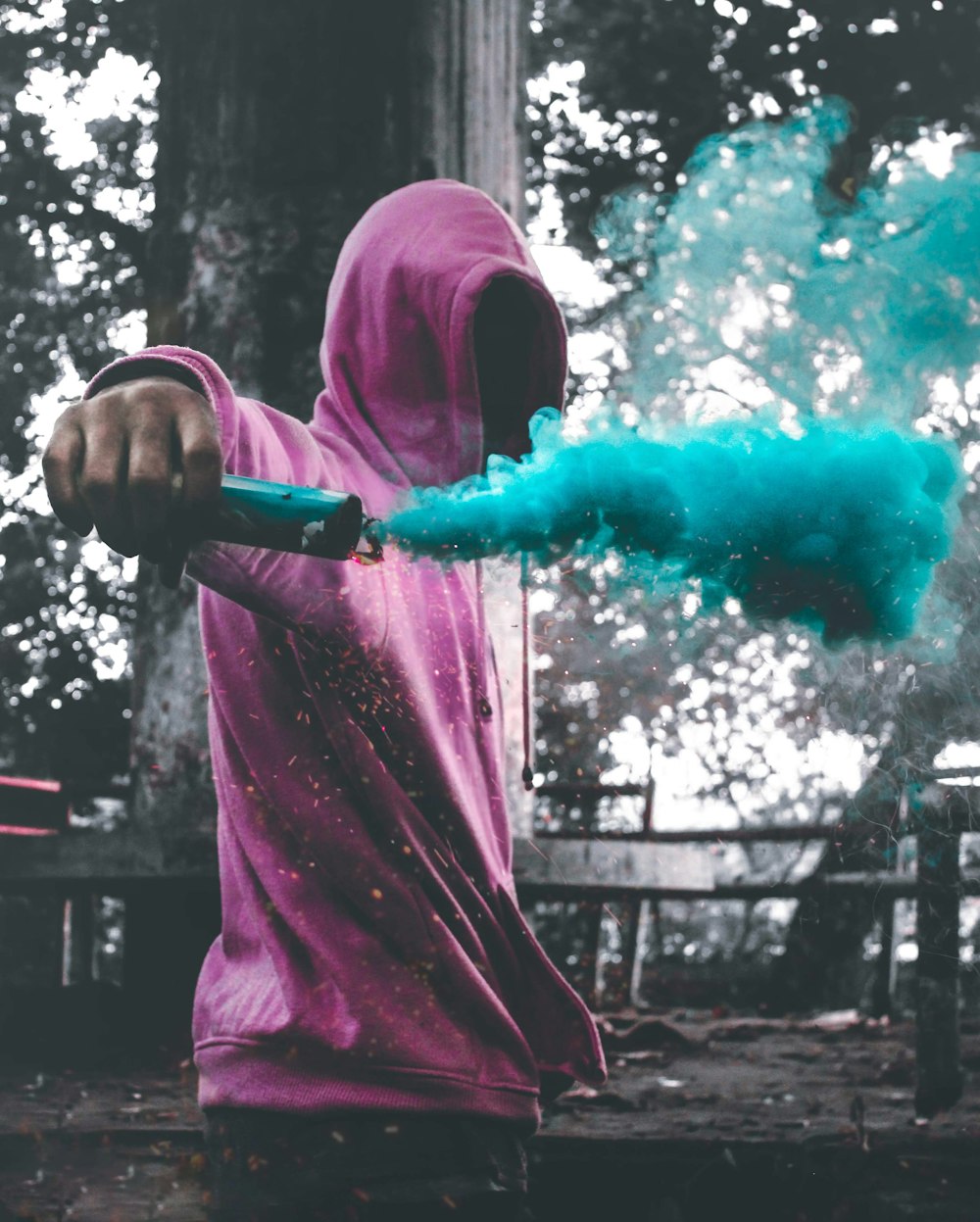 man wearing purple pullover holding smoke screen