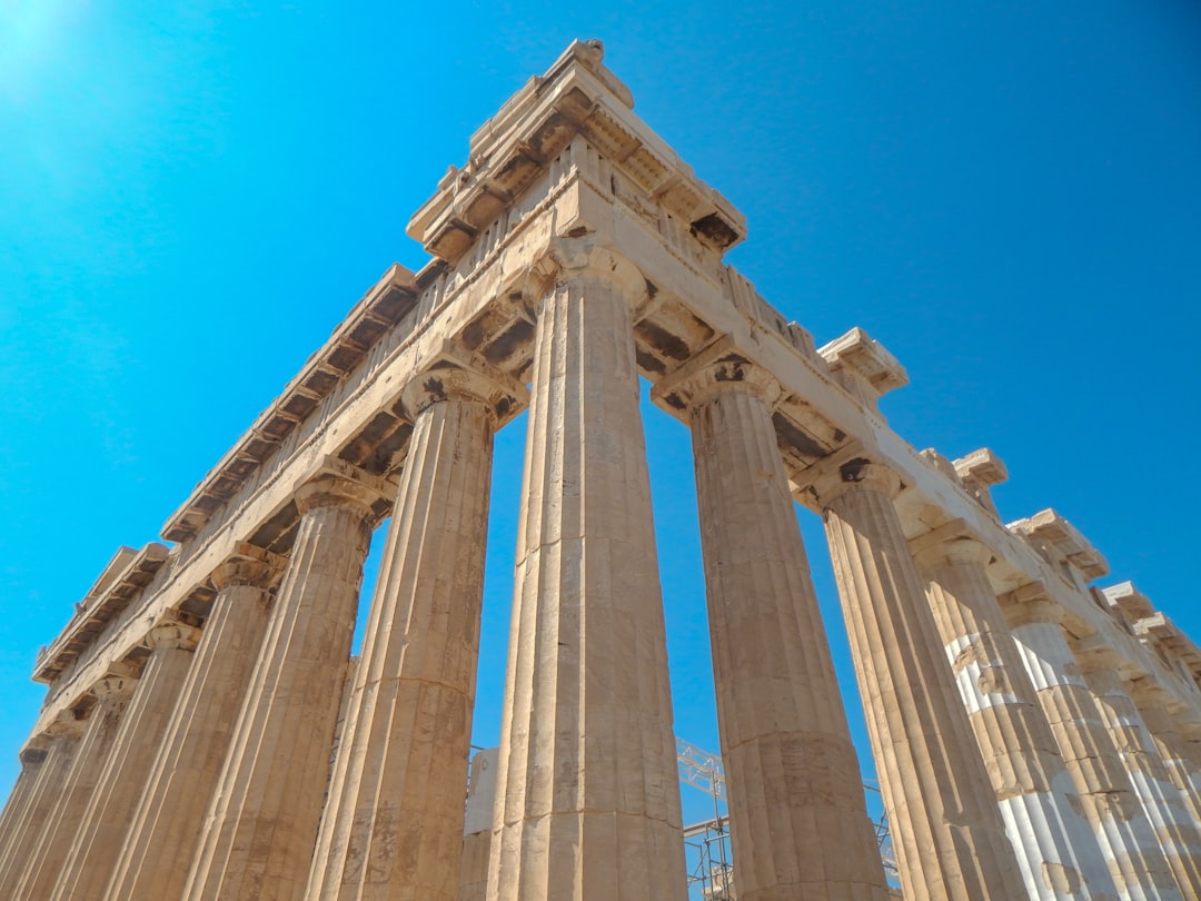 grey concrete post under blue sky, A close-up angle of the Parthenon in Athen, Greece.
