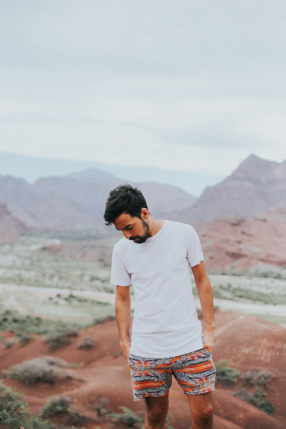 man wearing white crew-neck shirt across mountain