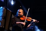 A musician playing a vintage violin on stage.