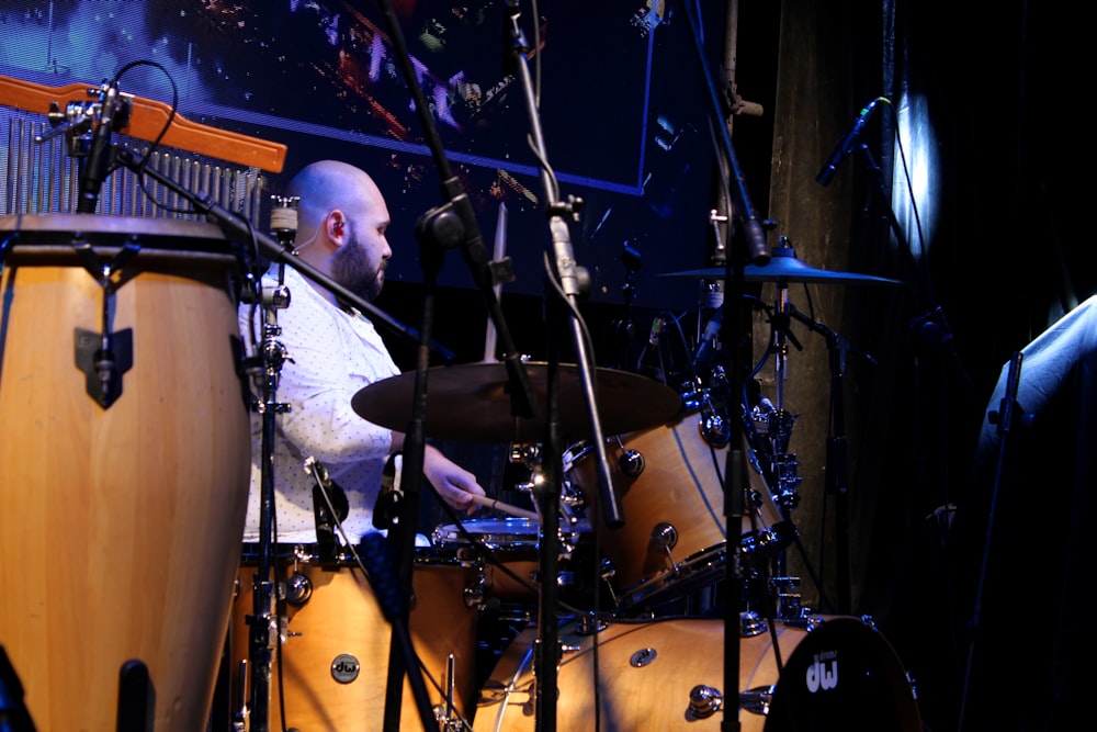 a man playing drums in front of a microphone