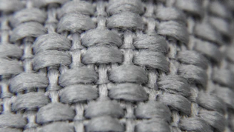 Close-up of rich navy and slate grey fabric textures showcasing fine weaving details.