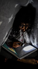 A cozy bedtime scene with a child reading a custom storybook under a blanket fort.