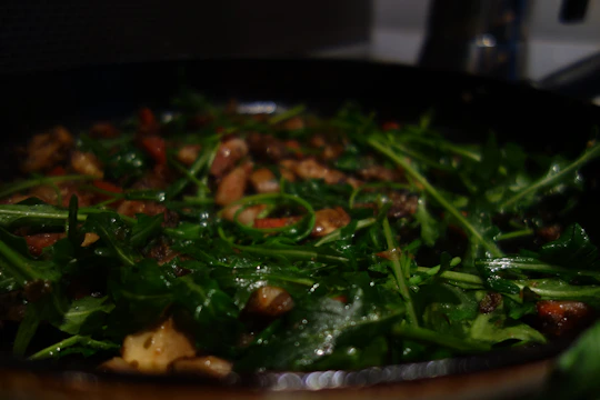 A busy chef quickly preparing a vibrant vegetable dish using pre-washed, ready-to-use greens.