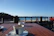 A smiling guest enjoying a morning coffee on the hotel's terrace overlooking the sea.