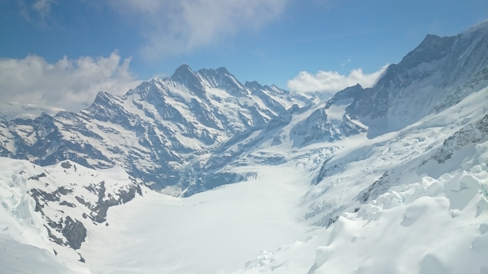 a view of a snowy mountain range from a ski lift