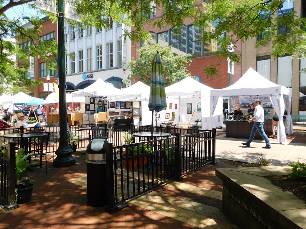 man walking beside of white canopy tent