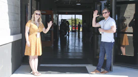 two man and woman standing on doorway
