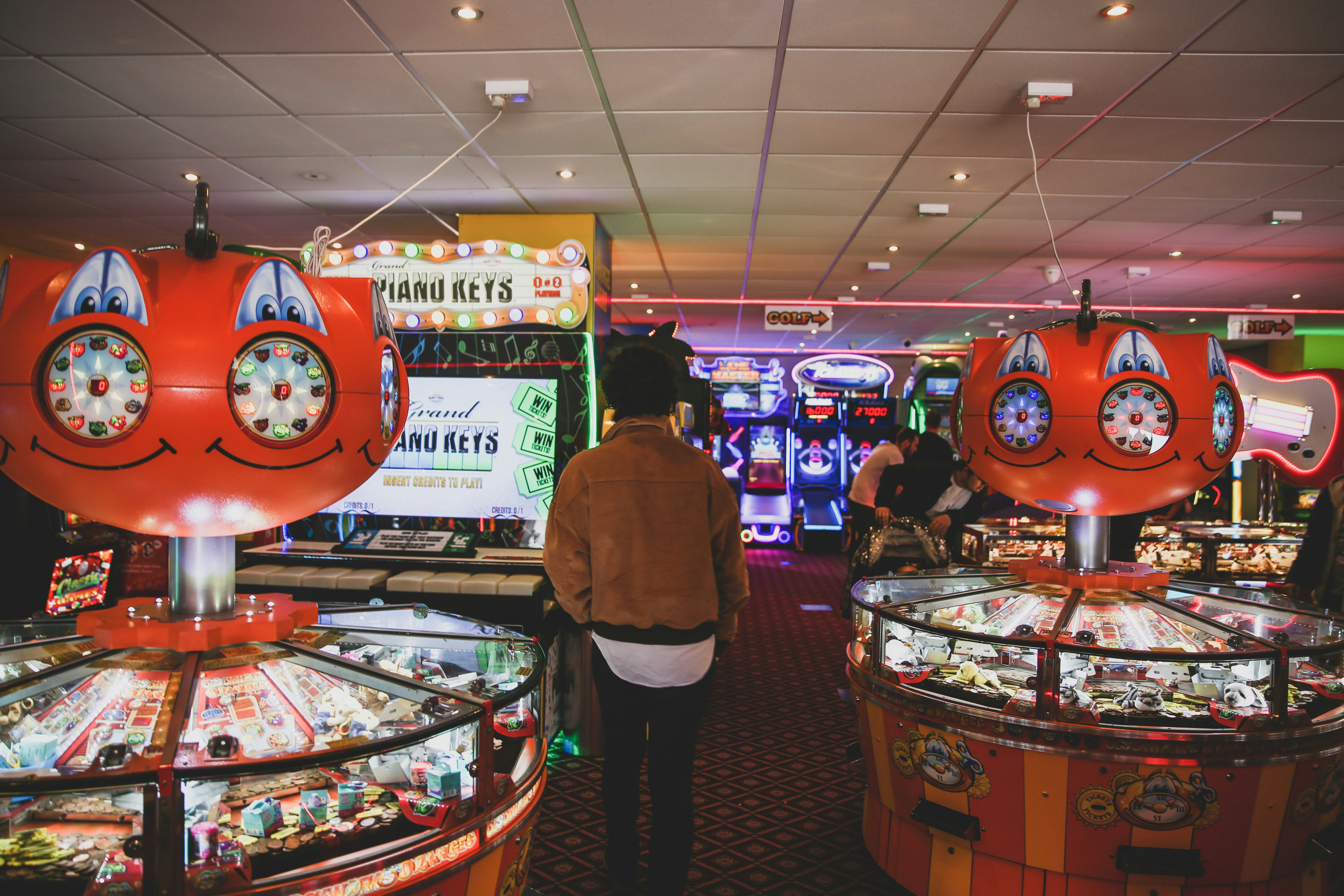 man wearing brown jacket inside arcade