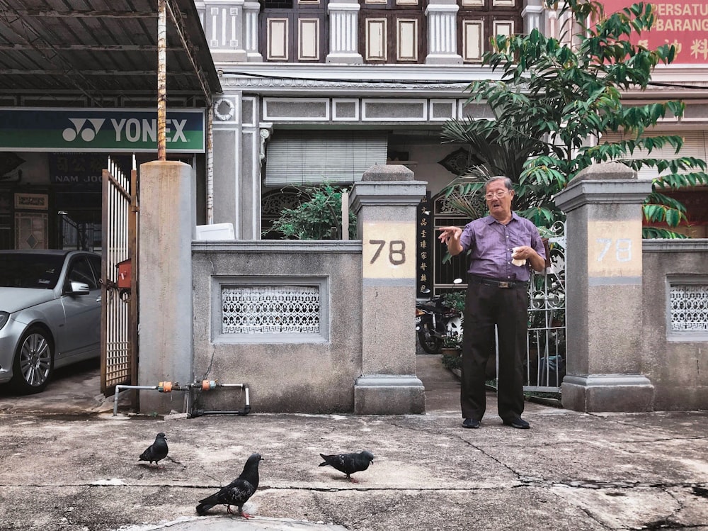 man wearing purple dress shirt and black pants