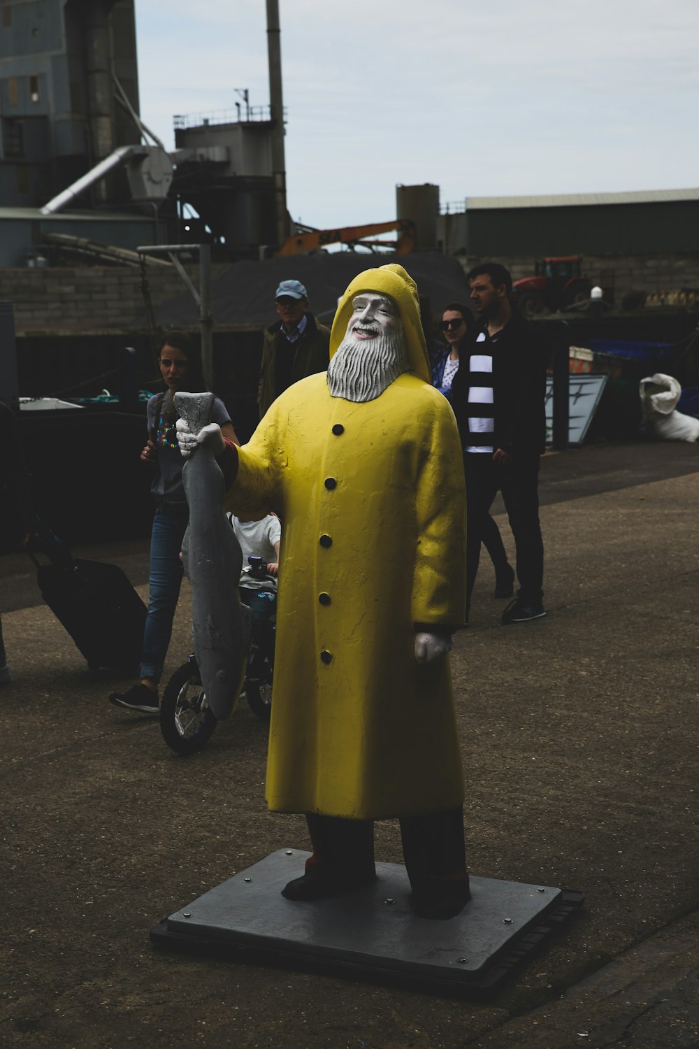 statue of man wearing yellow trench coat