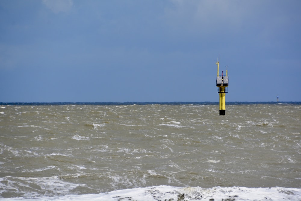 yellow tower on body of water during daytime