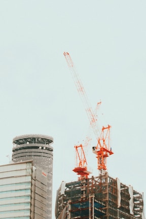 A large commercial building under construction with cranes.