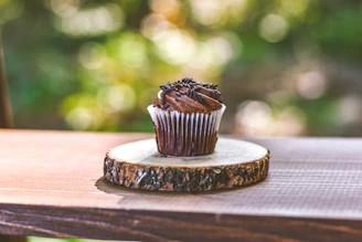 Freshly made kue cubit topped with chocolate sprinkles on a rustic wooden table