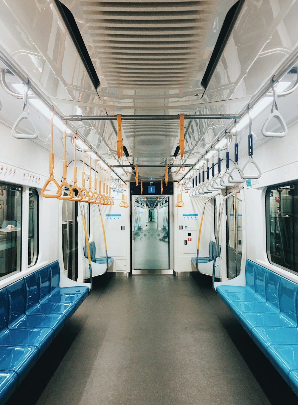 Un vagón de metro con asientos azules y una puerta