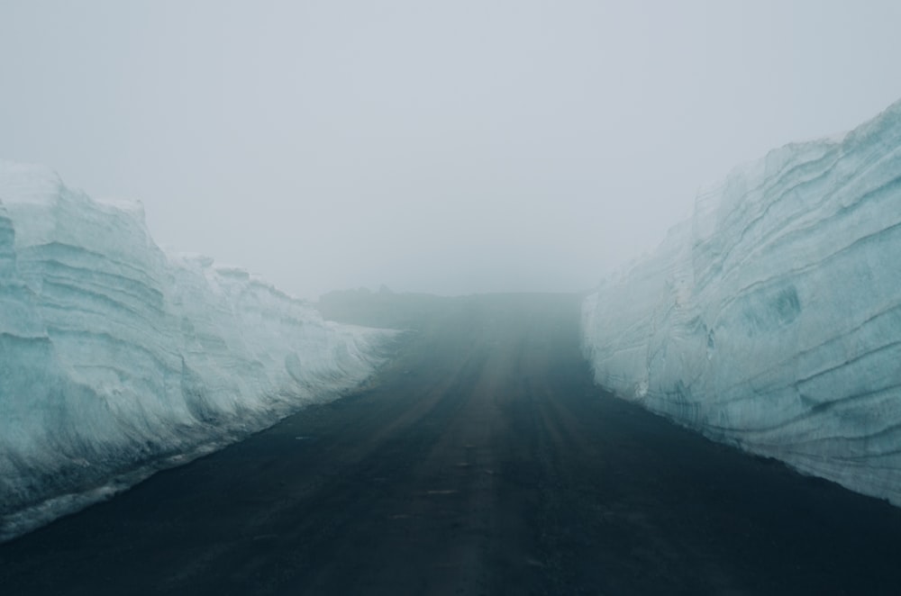 a foggy road with icebergs in the distance
