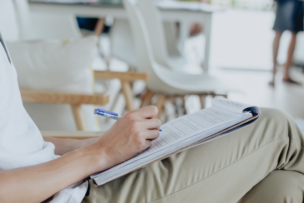 person writing on white sheet