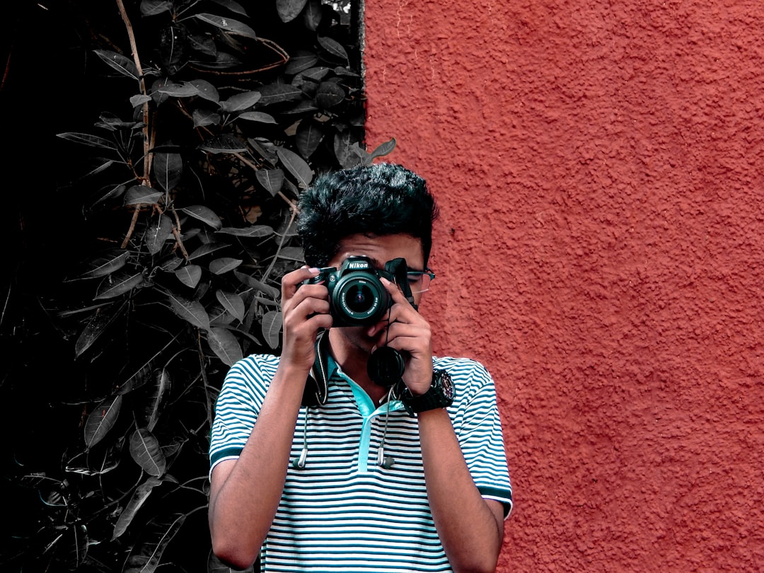 man holding camera during daytime,