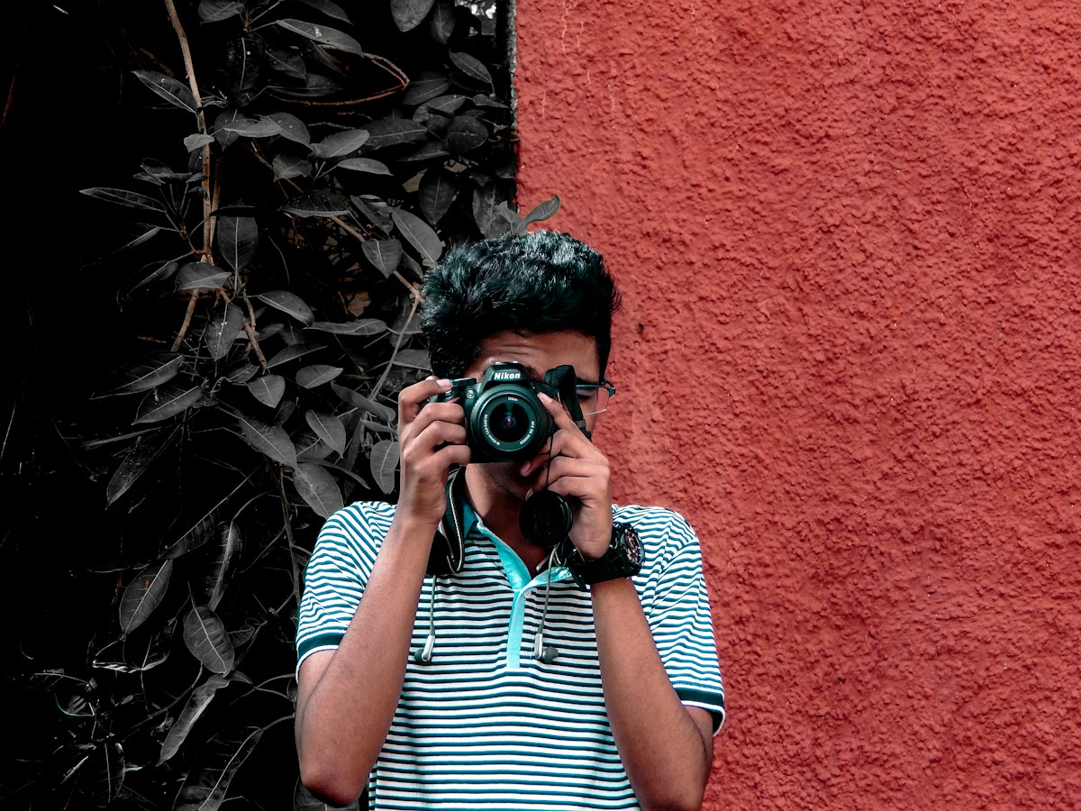 Man holding a camera outside, capturing moments at a church event, illustrating volunteer involvement in church event coordination