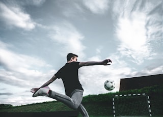man playing soccer during daytime