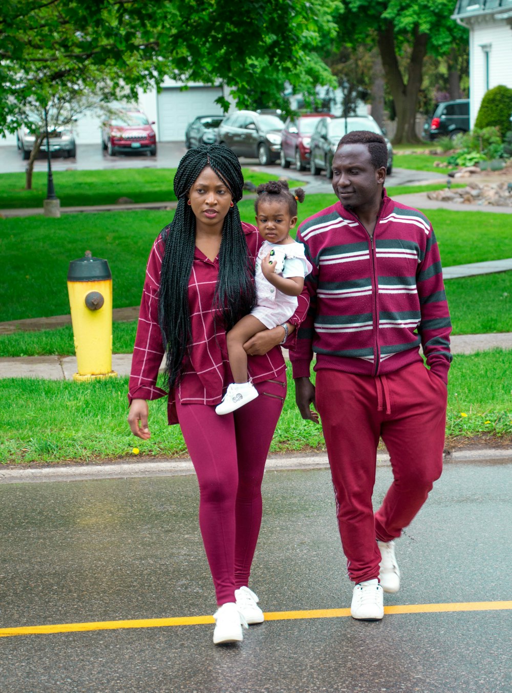 紫色の長袖シャツと紫色のレギンスを身に着けた女性が、ストリートの上を歩く幼児を乗せている