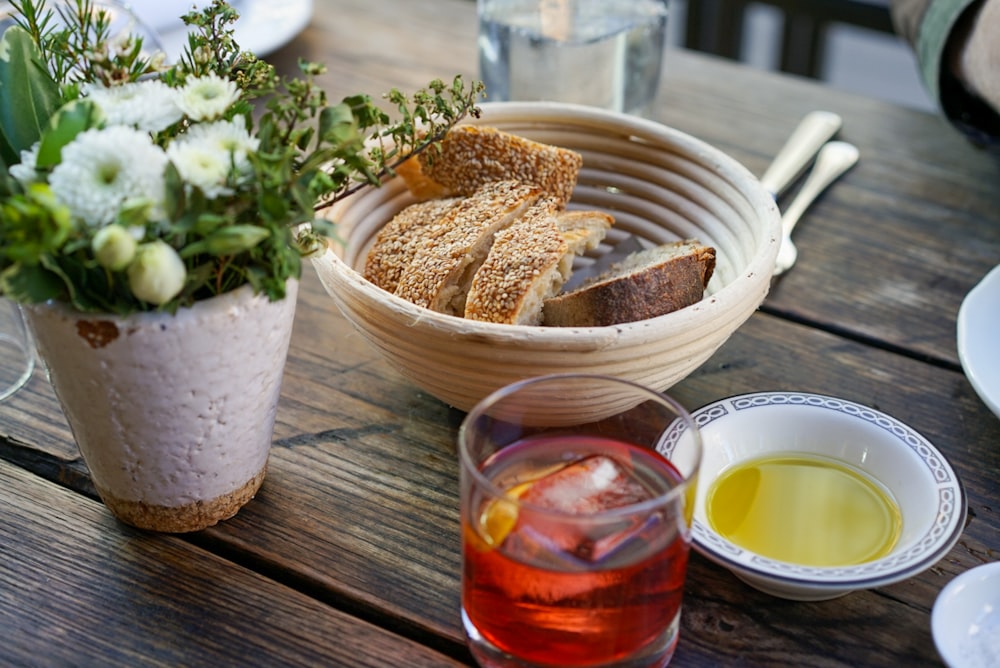 cooked food on bowl beside bowl and drinking glass