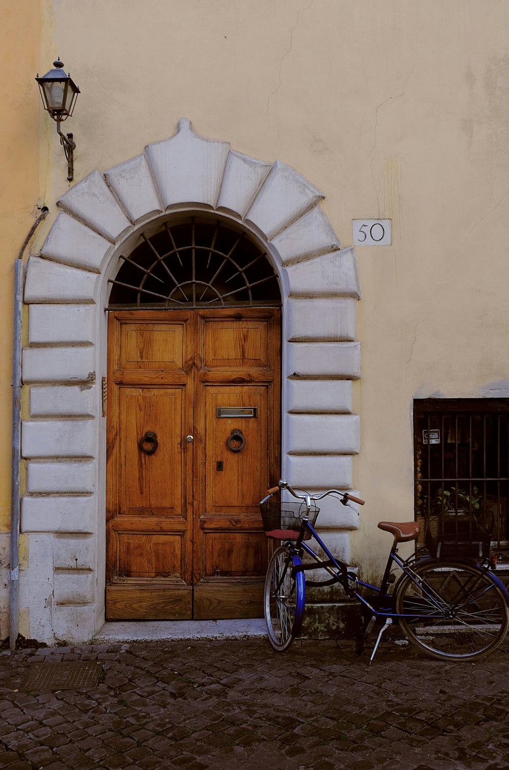 blue bicycle parked near closed brown wooden door