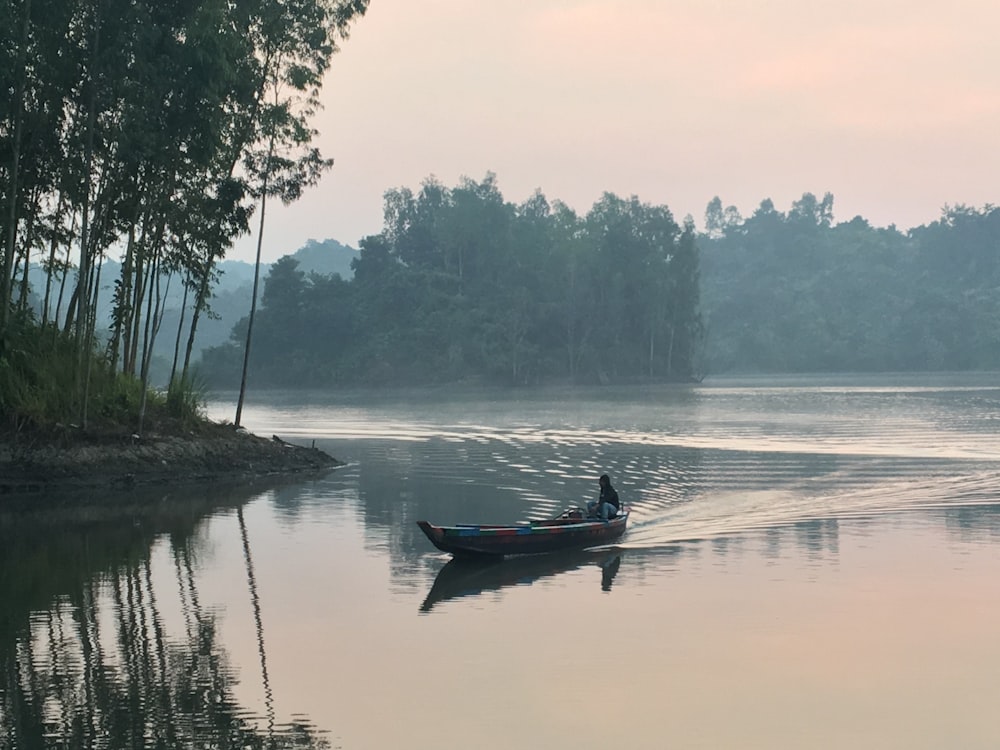 homme équipant un bateau près de l’île pendant la journée