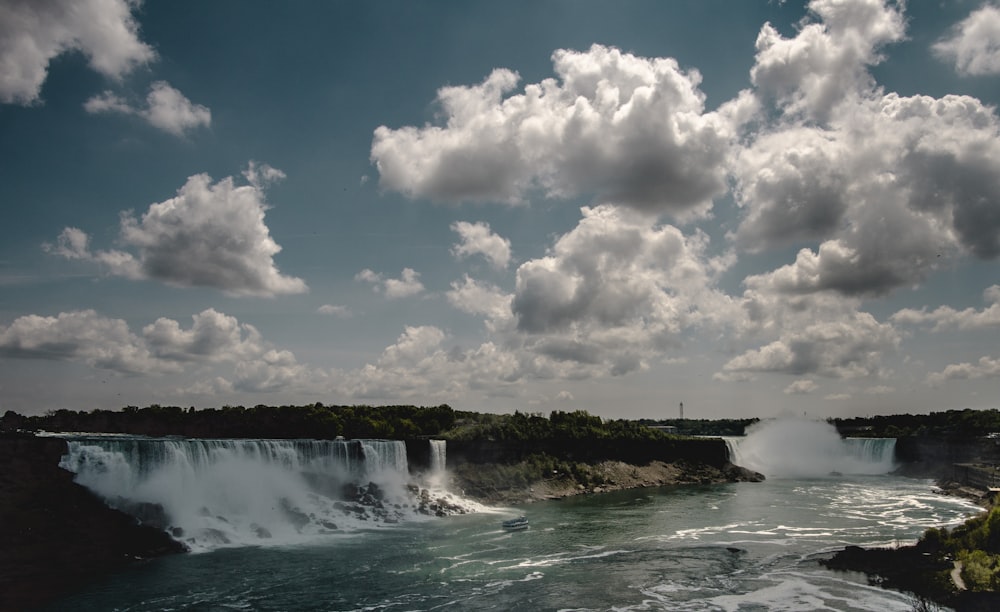 white clouds above waterfalls