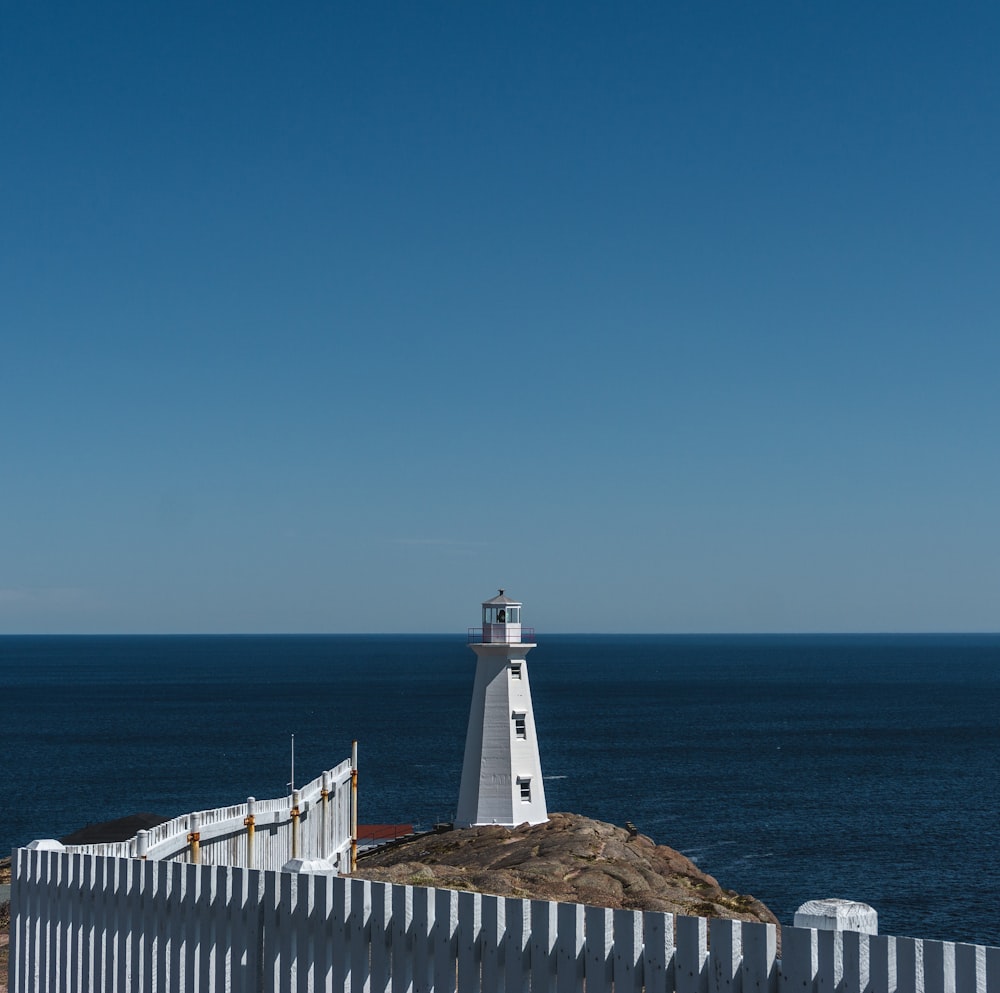 lighthouse on island mountain during day