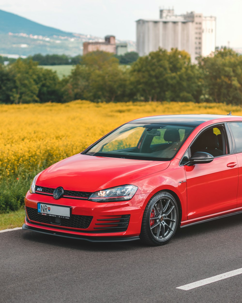 red Volkswagen Golf GTI 5-door hatchback parked in road