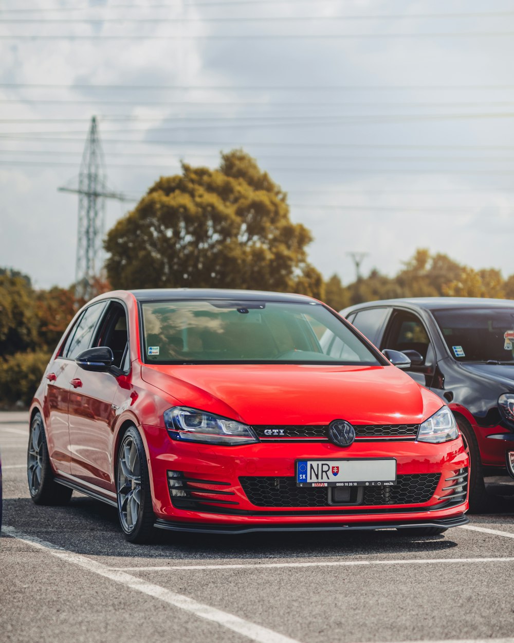 red Volkswagen Golf GTI 5-door hatchback in parking lot