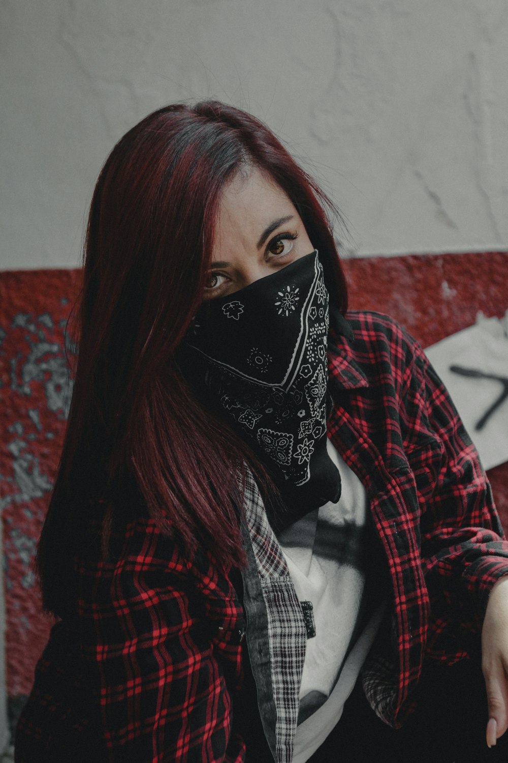 woman sitting and covering half face using black and white bandanna