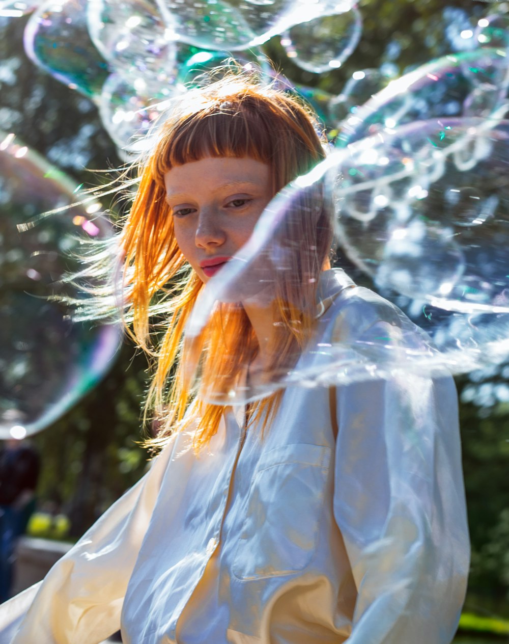 woman in white button-up shirt surrounded by bubbles