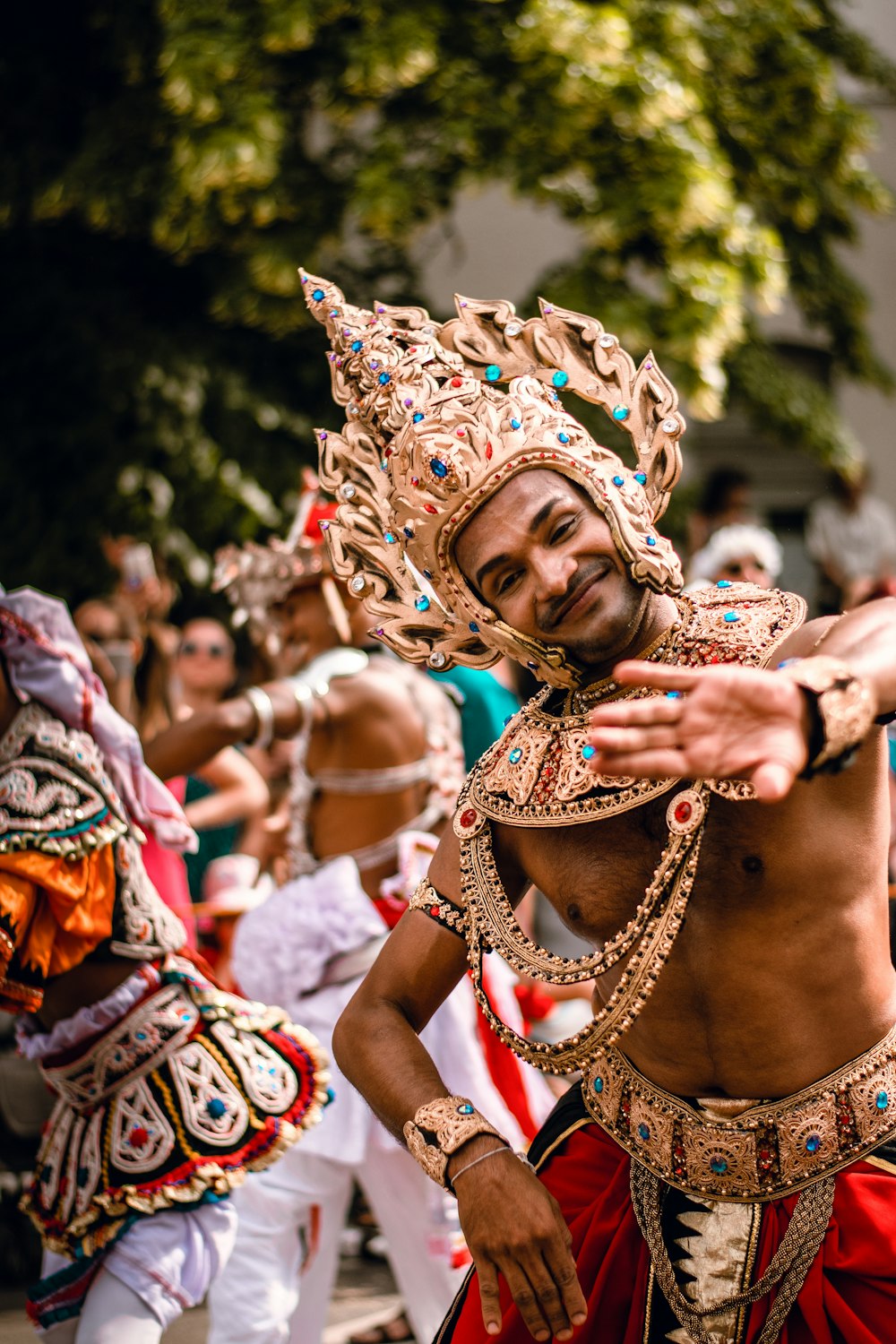men with golden headdresses dancing on street