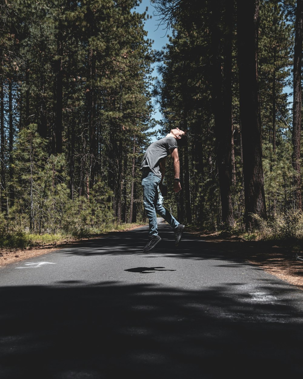 man jumping in the middle of road