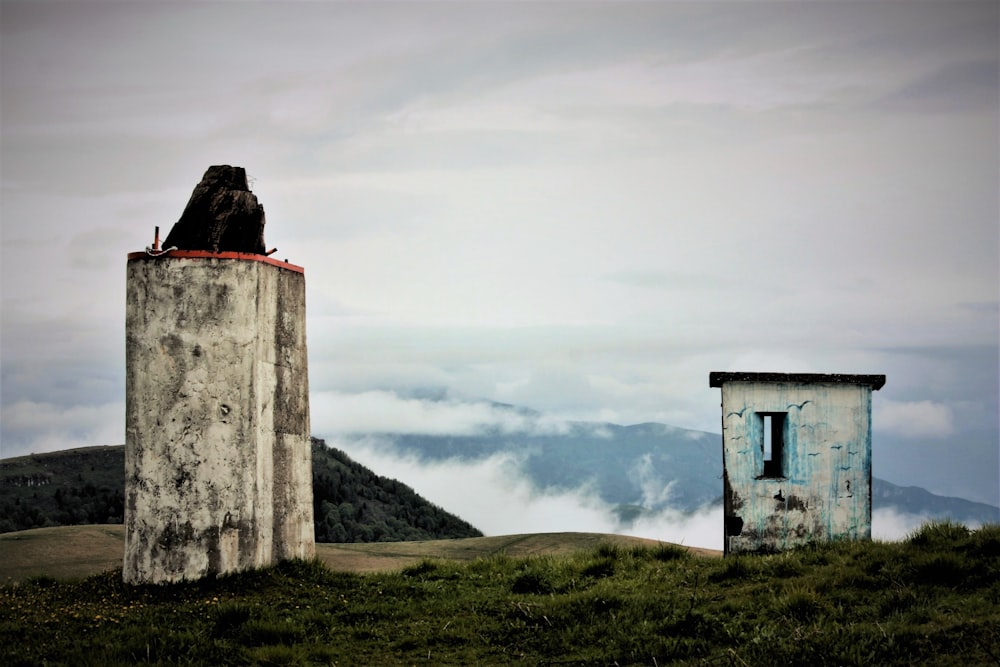 white and gray concrete house in green field under gray and white skies