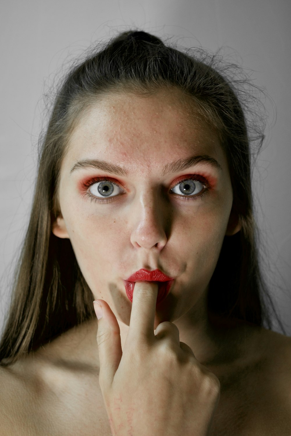 woman with finger on mouth inside room