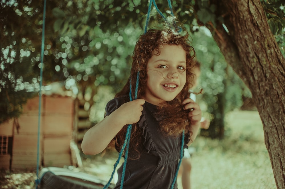 girl standing on swing during daytime