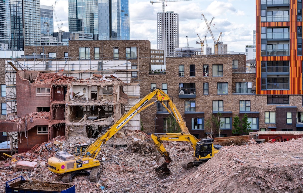 yellow backhoe on ground near buildings